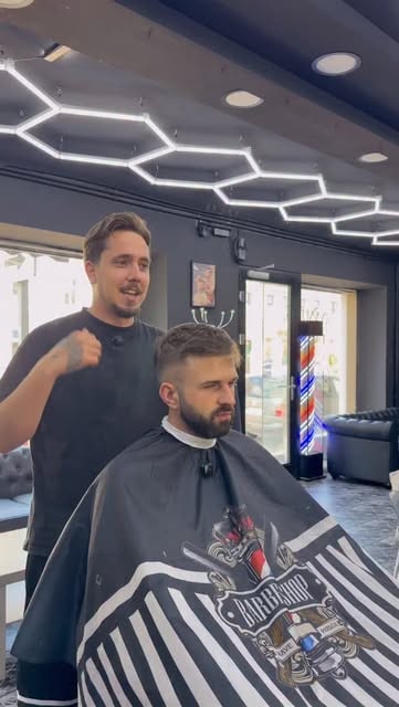 Barbier mit Kunde im Stuhl nach dem Schnitt bei Damian Barber